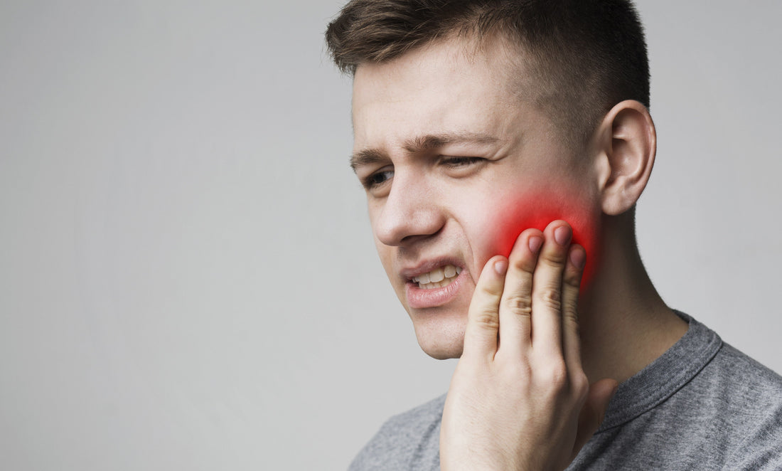 Individual holding jaw in discomfort, indicating common TMJ symptoms like pain and difficulty chewing